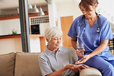 Buy stock photo Shot of a female doctor giving medication to a senior patient