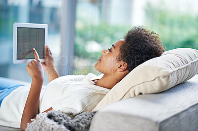 Buy stock photo Tablet, smile and touch screen for relax woman, sofa and resting in home living room. Technology, screen and happy African woman with afro, couch and social media online for internet communication