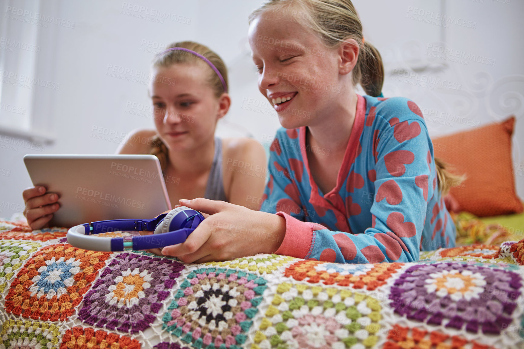 Buy stock photo Shot of two teenage friends using a digital tablet together at home