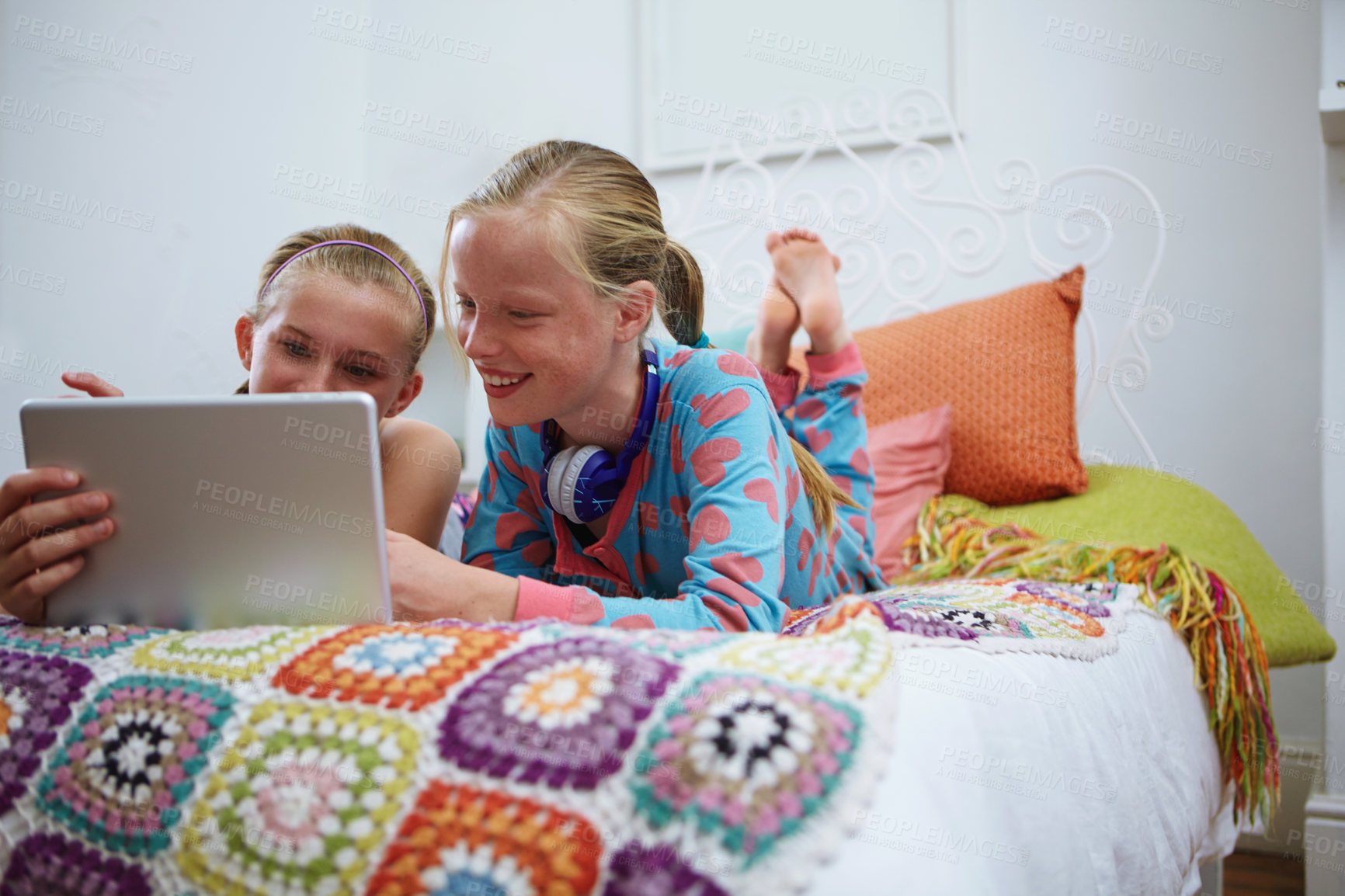 Buy stock photo Shot of two teenage friends using a digital tablet together at home