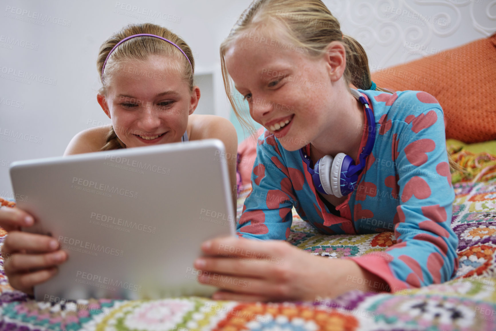 Buy stock photo Shot of two teenage friends using a digital tablet together at home