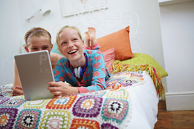 Buy stock photo Shot of two teenage friends using a digital tablet together at home