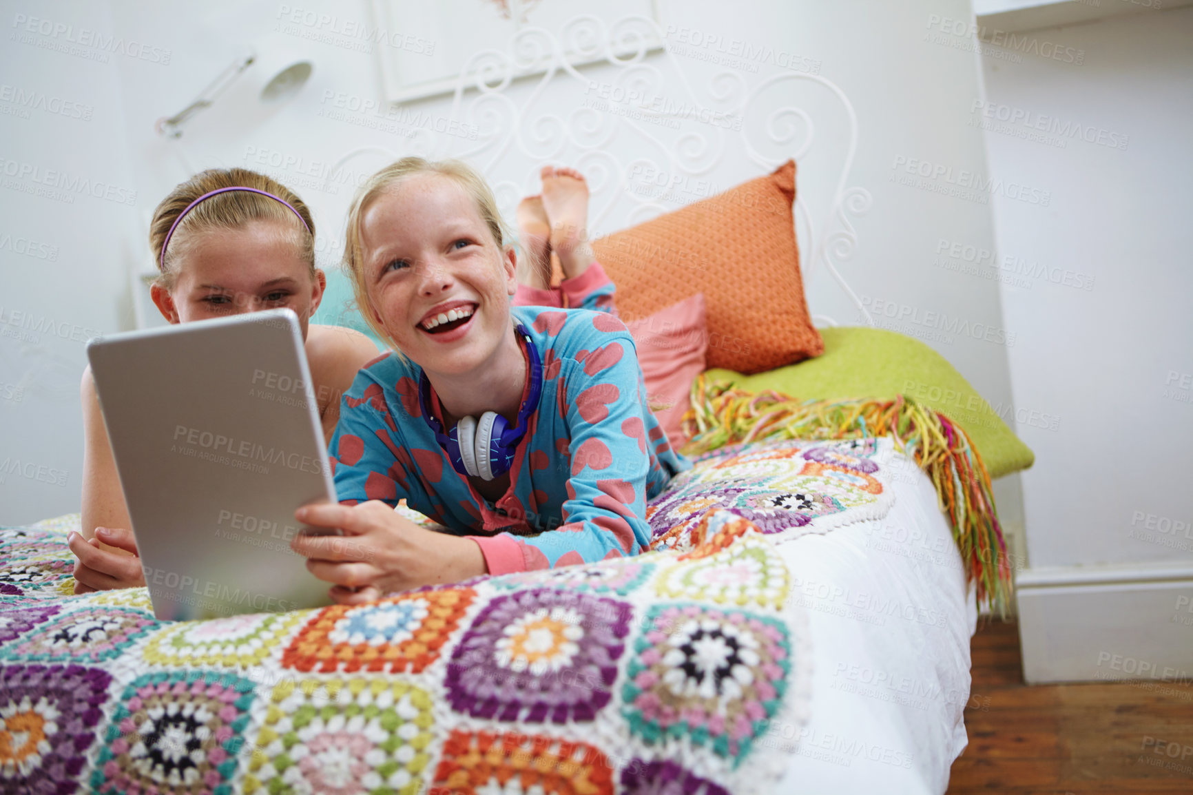 Buy stock photo Shot of two teenage friends using a digital tablet together at home