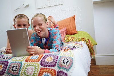 Buy stock photo Shot of two teenage friends using a digital tablet together at home