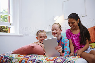 Buy stock photo Shot of a group of teenage friends using a digital tablet together