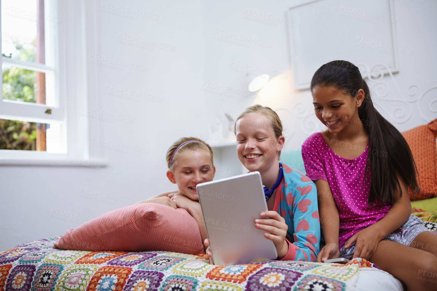 Buy stock photo Shot of a group of teenage friends using a digital tablet together