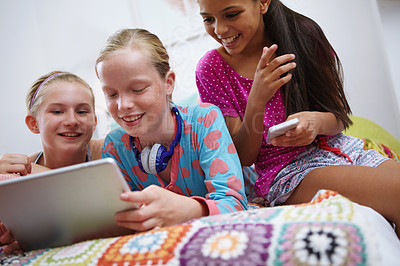 Buy stock photo Shot of a group of teenage friends using a digital tablet together