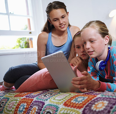 Buy stock photo Shot of a group of teenage friends using a digital tablet together