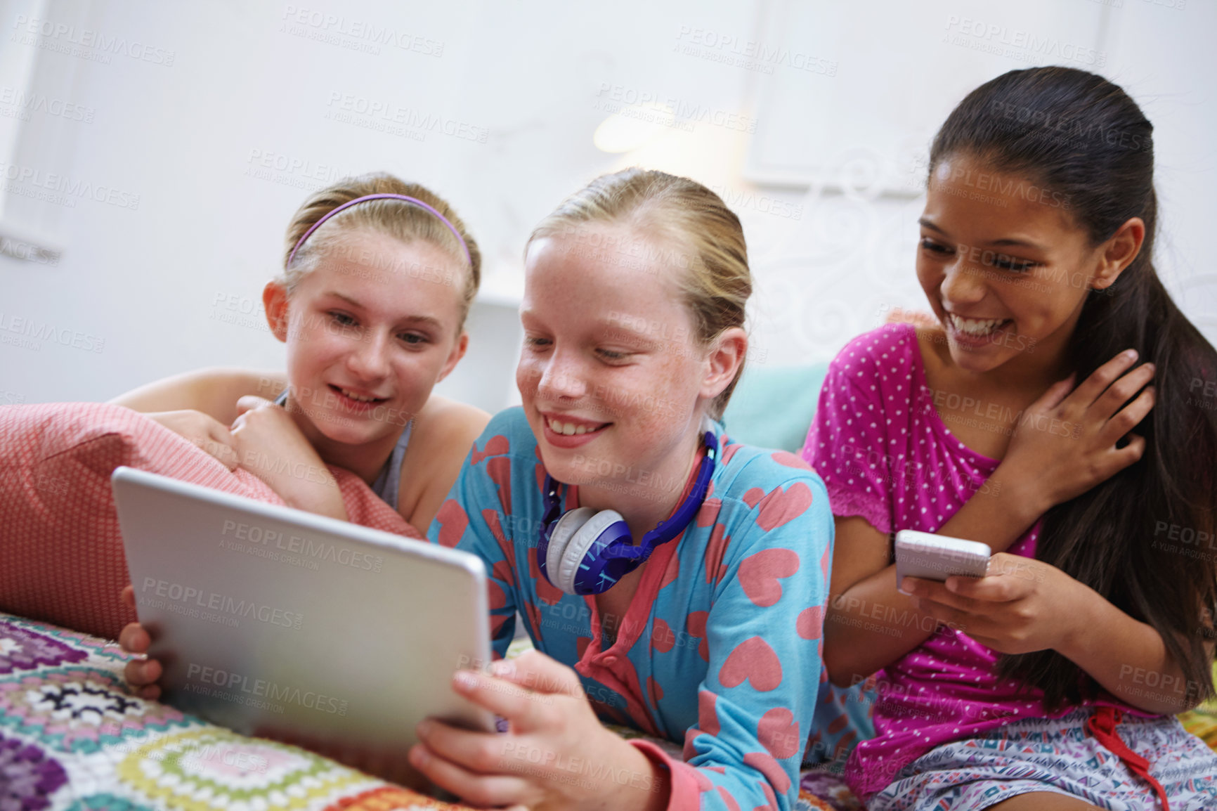 Buy stock photo Shot of a group of teenage friends using a digital tablet together