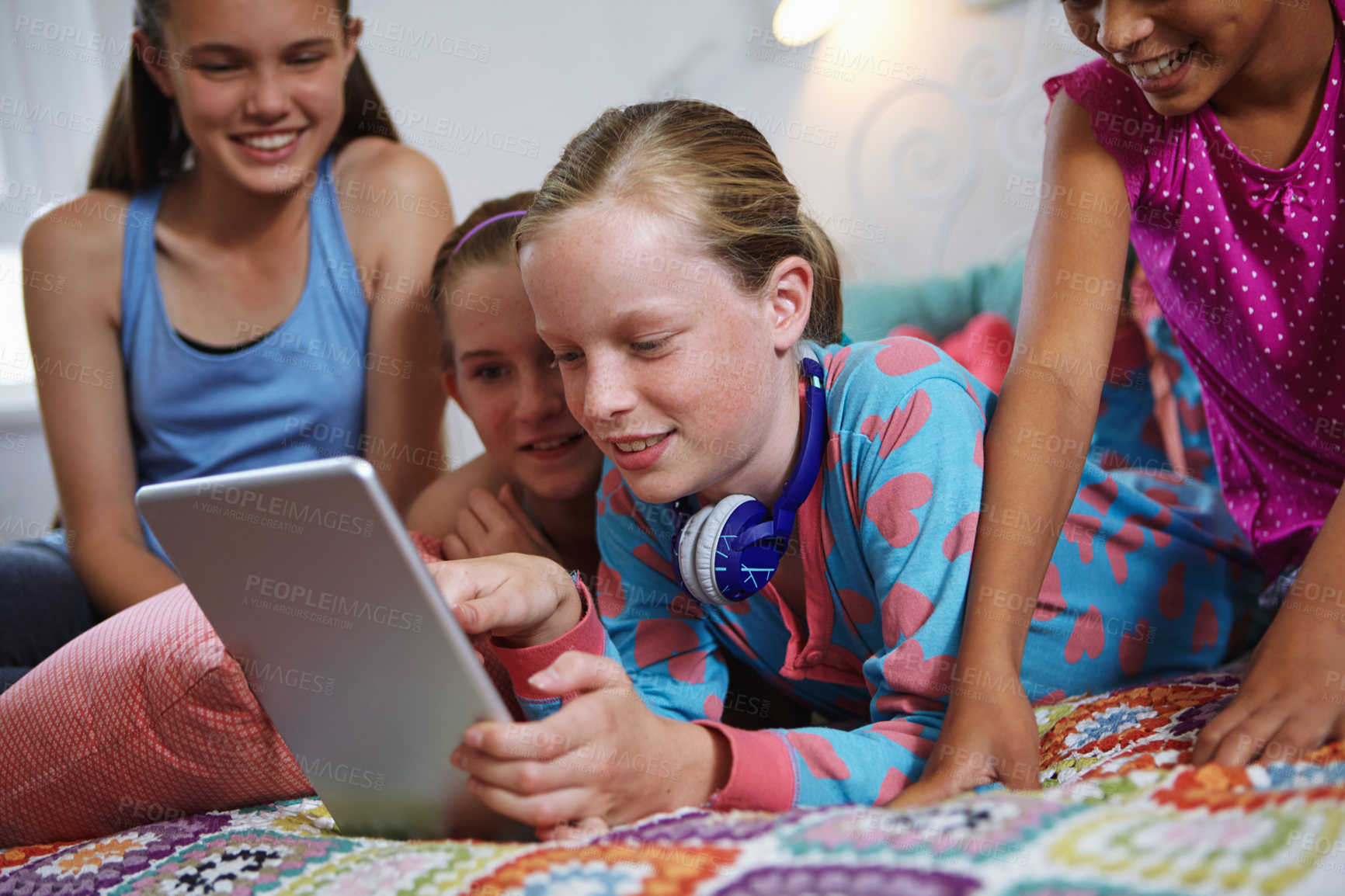 Buy stock photo Shot of a group of teenage friends using a digital tablet together