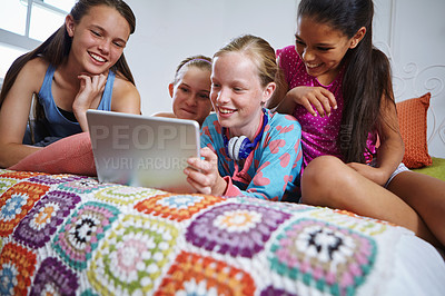 Buy stock photo Shot of a group of teenage friends using a digital tablet together