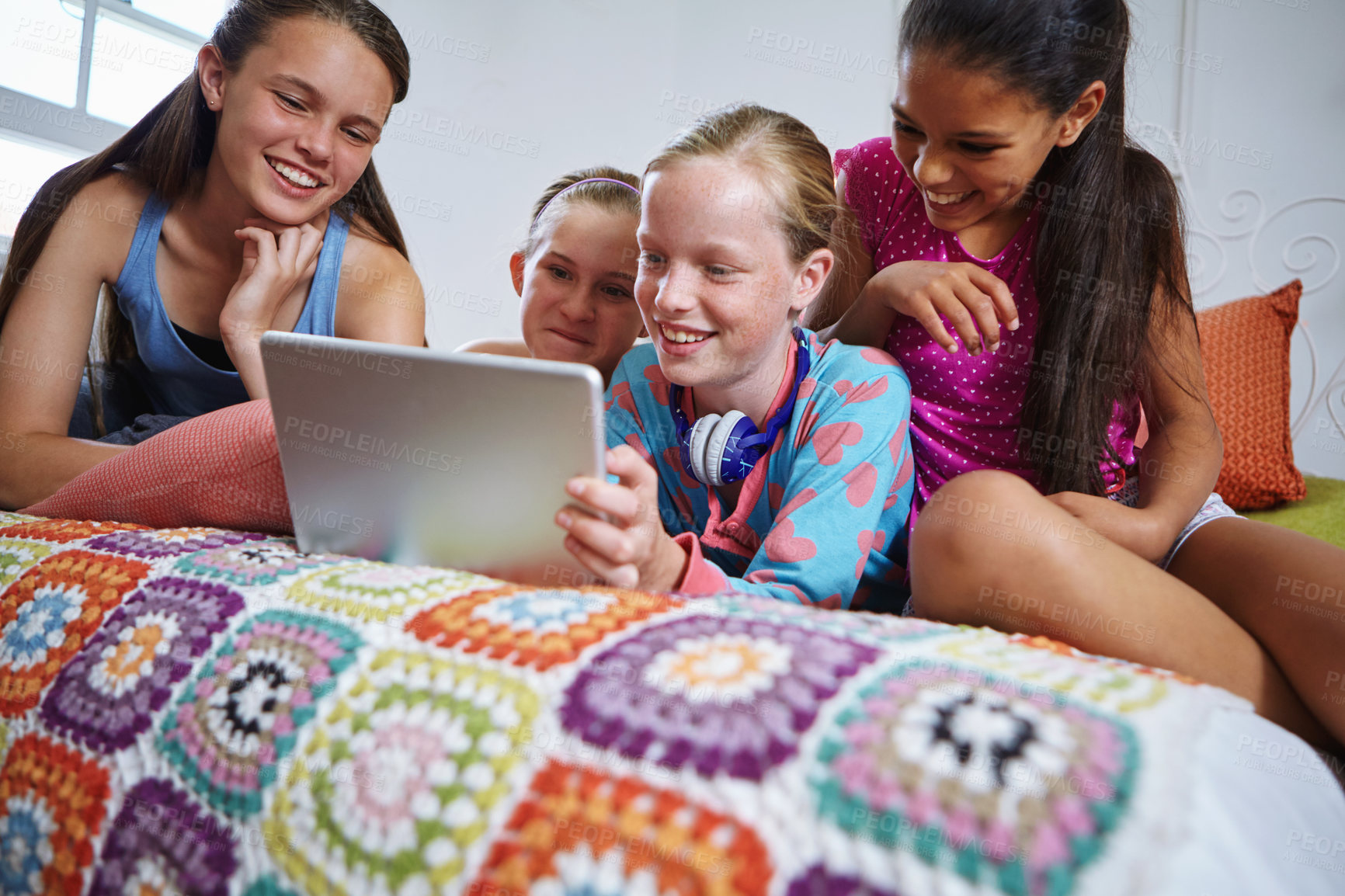 Buy stock photo Shot of a group of teenage friends using a digital tablet together