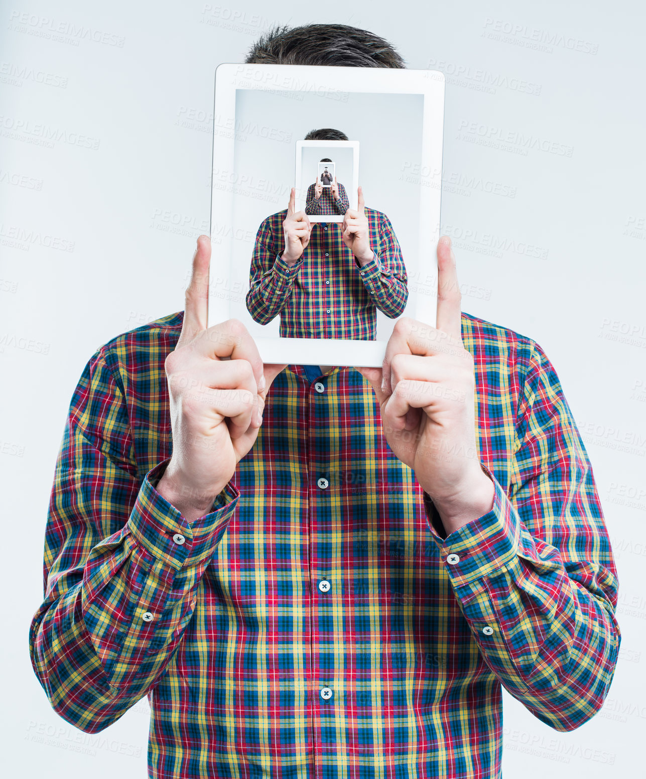 Buy stock photo Surreal shot of a young man holding an advanced digital tablet in front of his face, duplicated