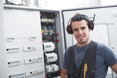 Buy stock photo Portrait, happy man and electrician in industry for maintenance, inspection or repair. Electrical engineer, breaker and distribution board for power system, contractor and technician with headphones