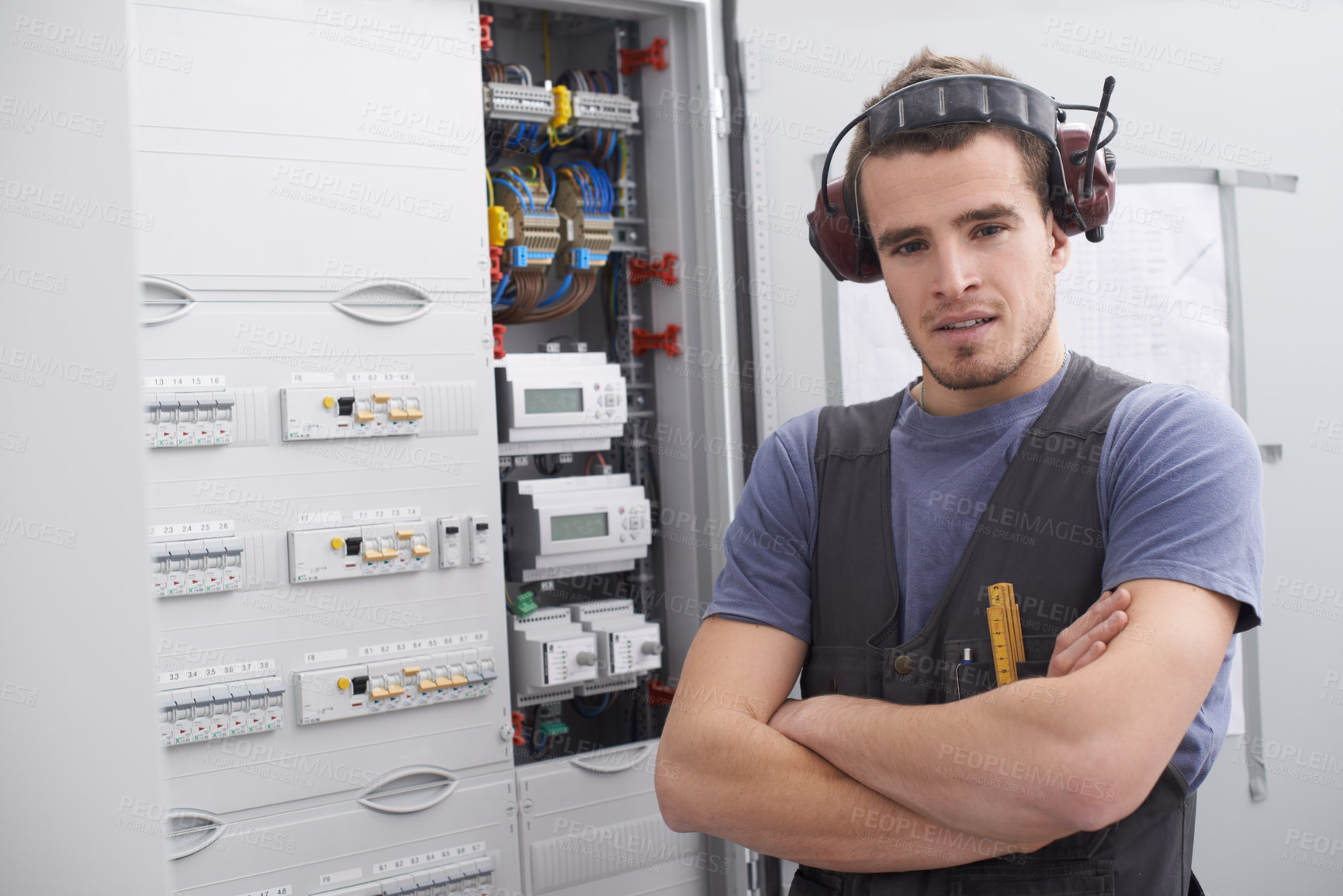 Buy stock photo Portrait, electrical engineer and man with arms crossed, control room and confident for power generation. Maintenance, contractor and person with noise cancelling headphones, cables and installation