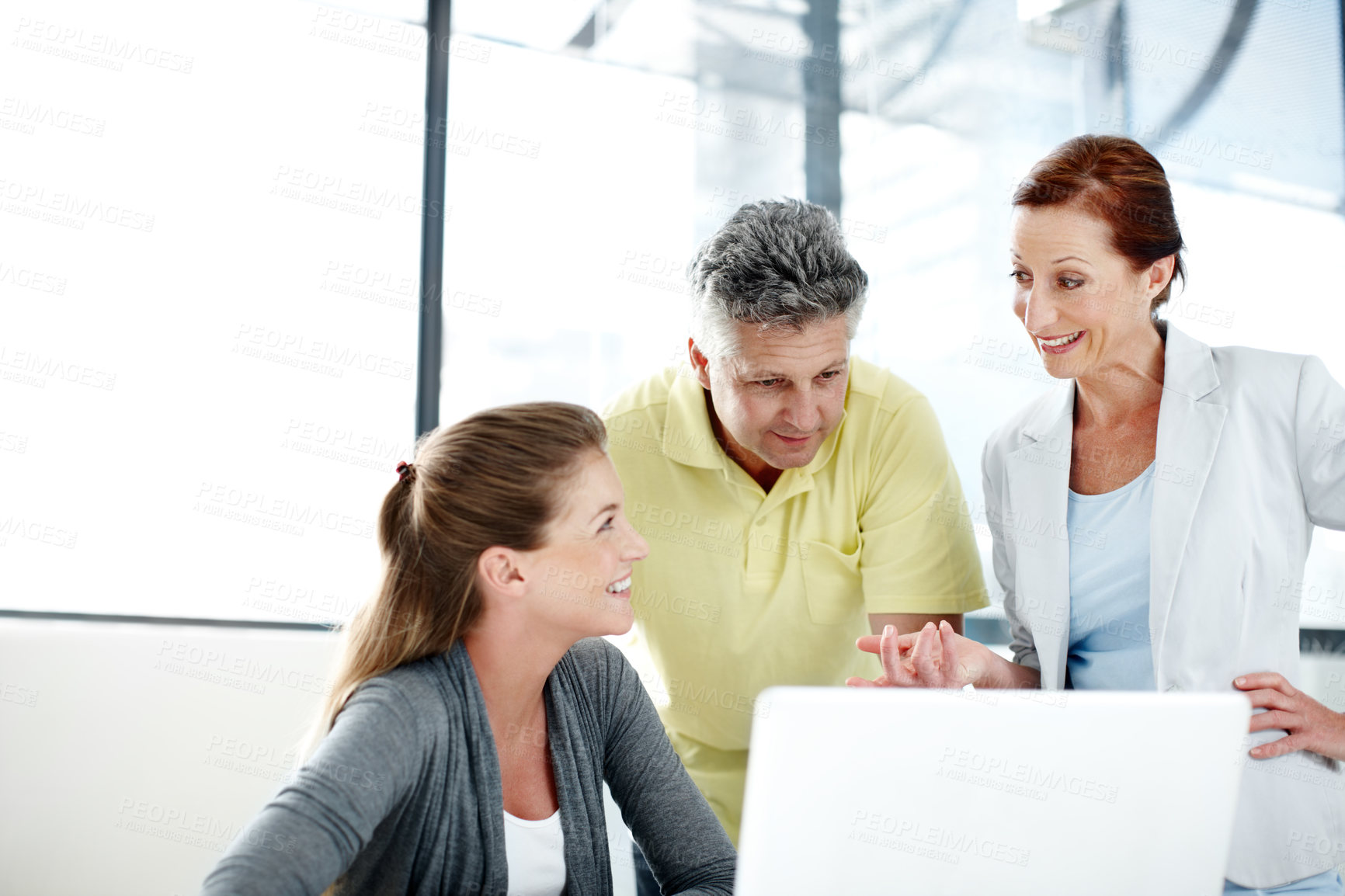 Buy stock photo A group of professionals working together as a team at a laptop