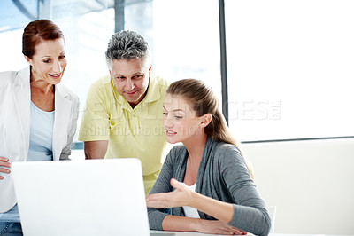 Buy stock photo A group of professionals working together as a team at a laptop