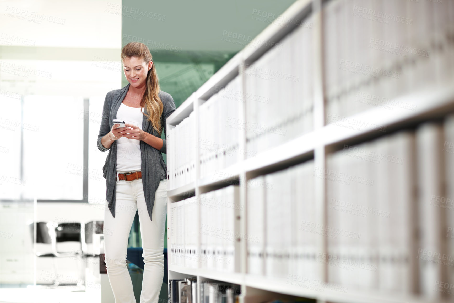 Buy stock photo A young businesswoman standing and communicating with her mobile phone