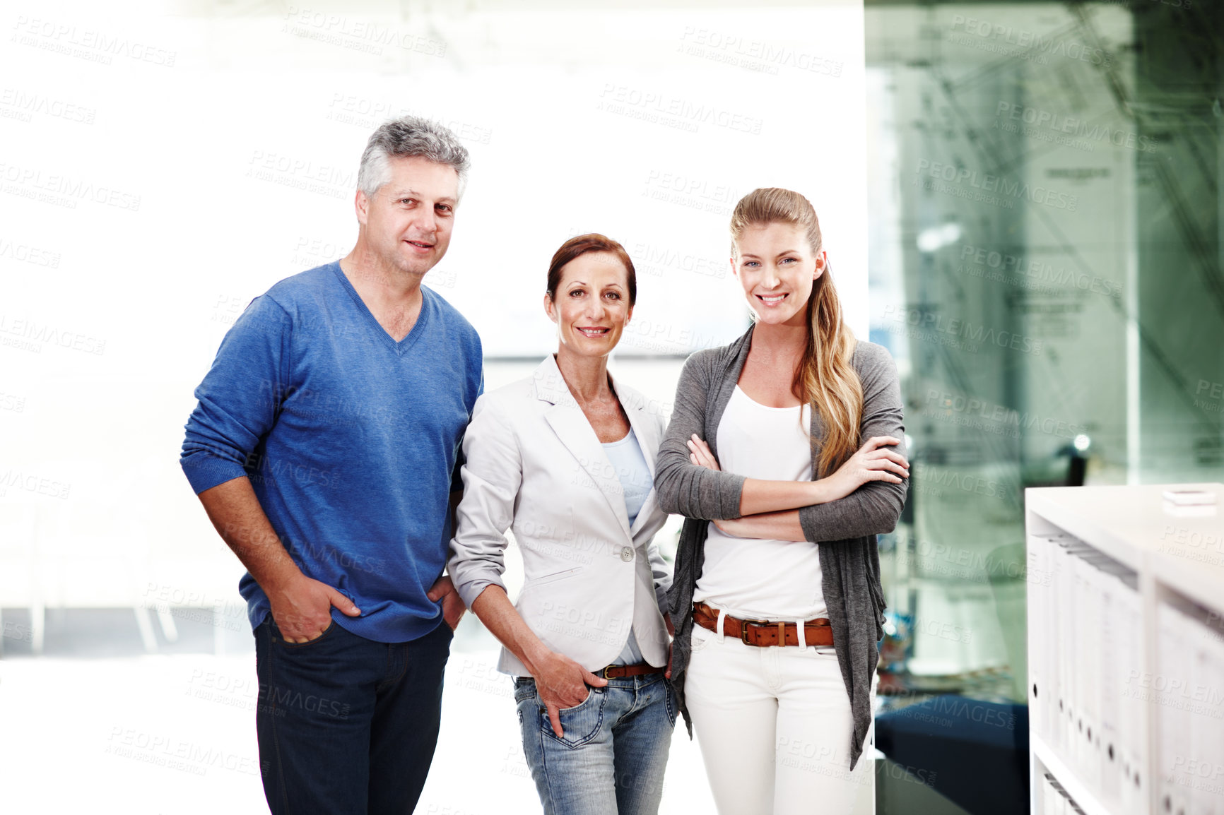 Buy stock photo A group of three casual businesspeople standing next to each other in a row