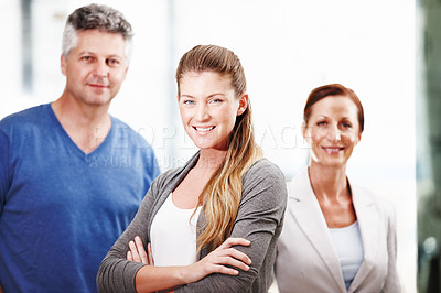 Buy stock photo A group of three casual businesspeople standing next to each other