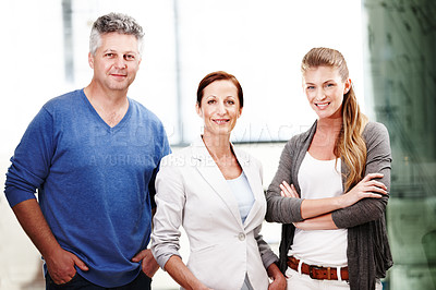 Buy stock photo Portrait of three casual office workers standing next to each other and smiling at the camera