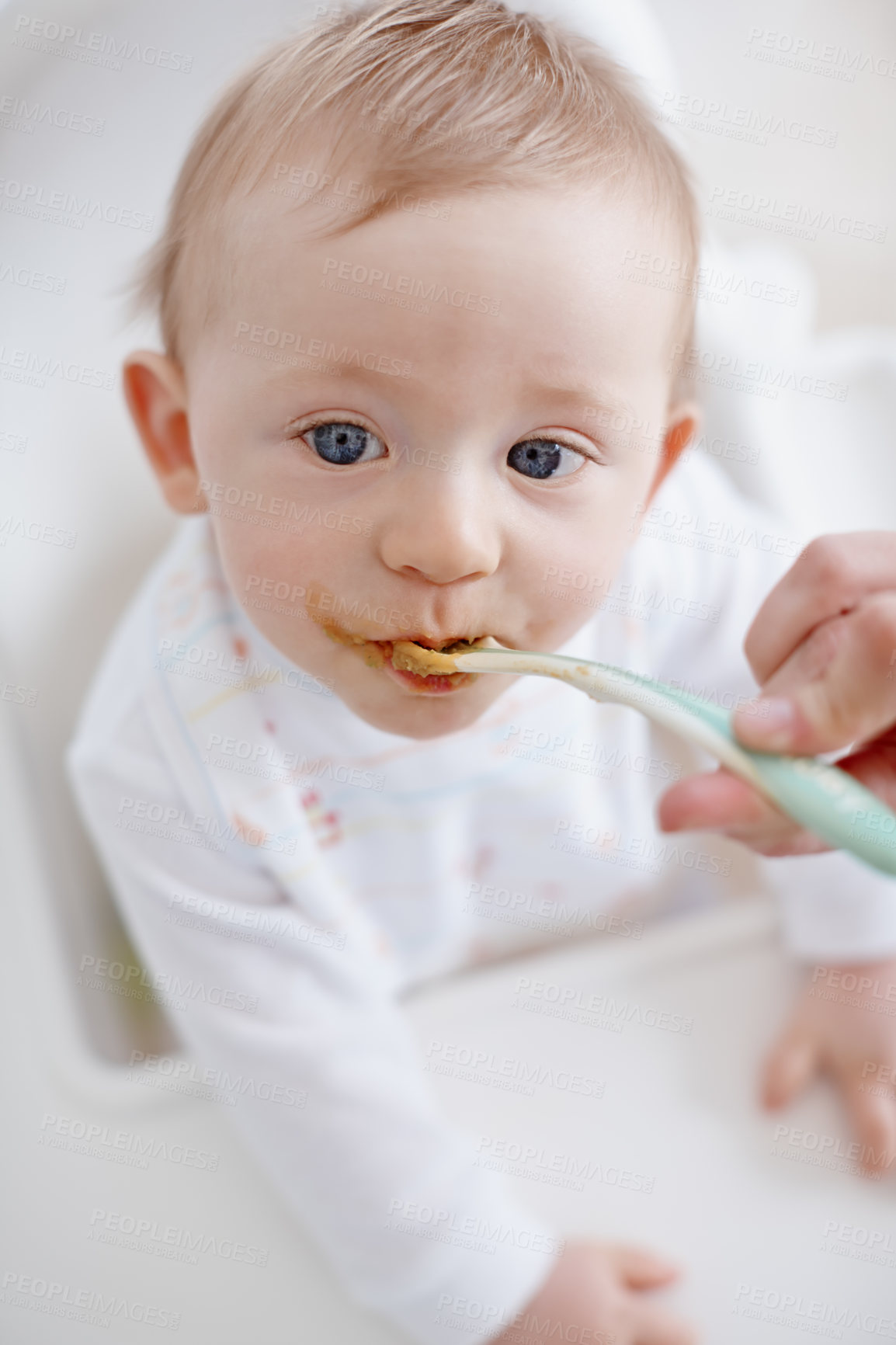 Buy stock photo High angle view of a baby boy being fed by his mother