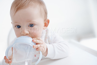 Buy stock photo Cropped image a cute baby boy drinking from his sippy cup