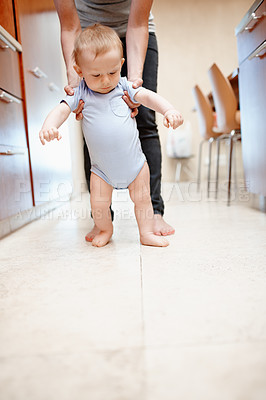 Buy stock photo A cute baby boy being assisted by his mother to walk