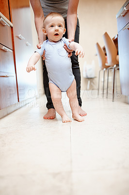 Buy stock photo A cute baby boy being assisted by his mother to walk