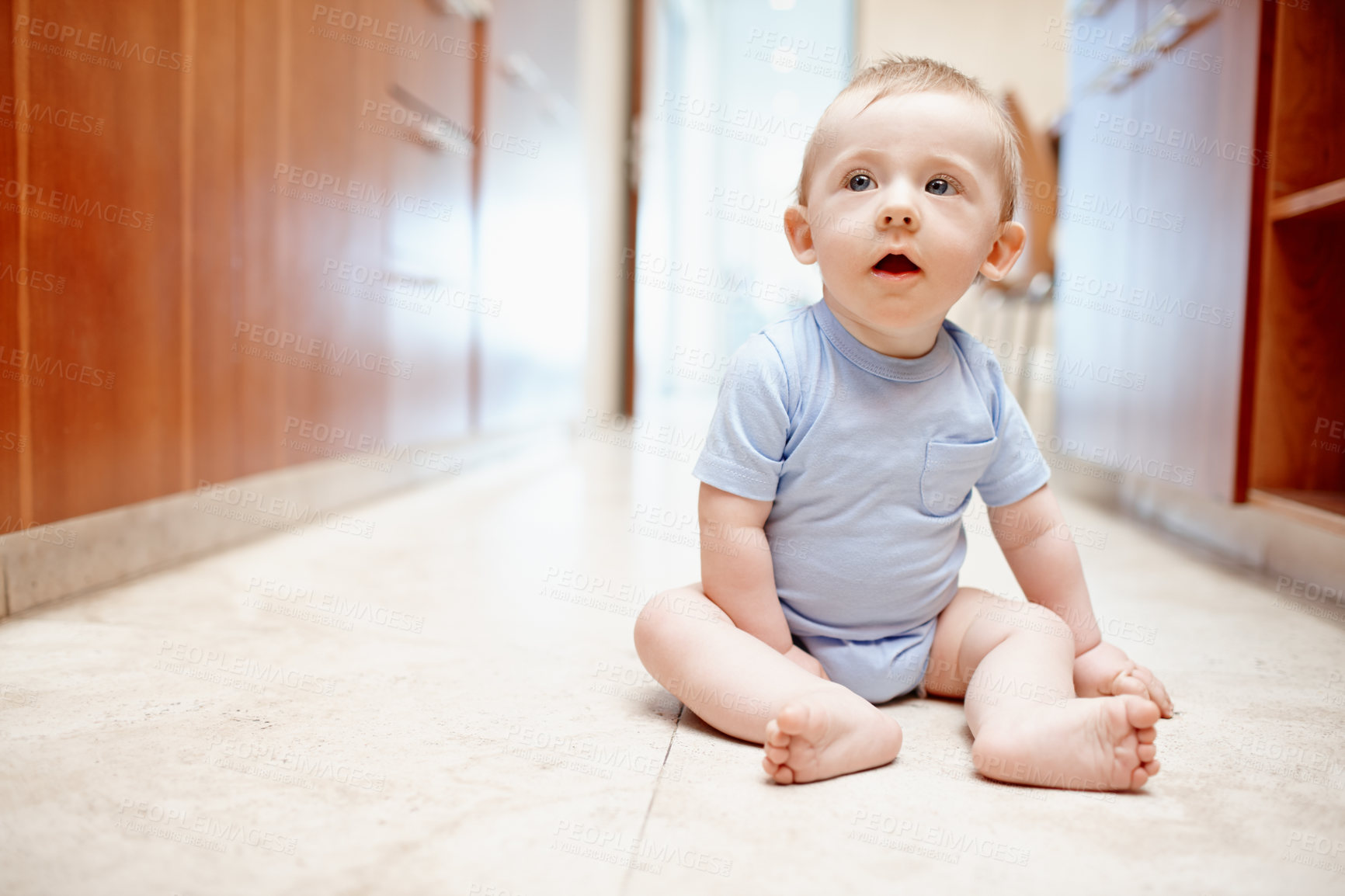 Buy stock photo A baby boy sitting on the kitchen floor