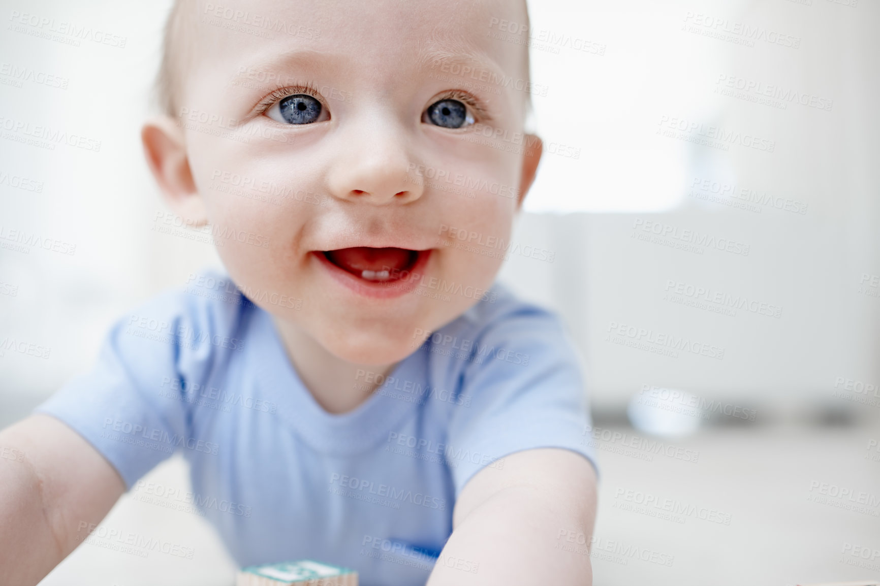 Buy stock photo A sweet little boy smiling while lying on his tummy