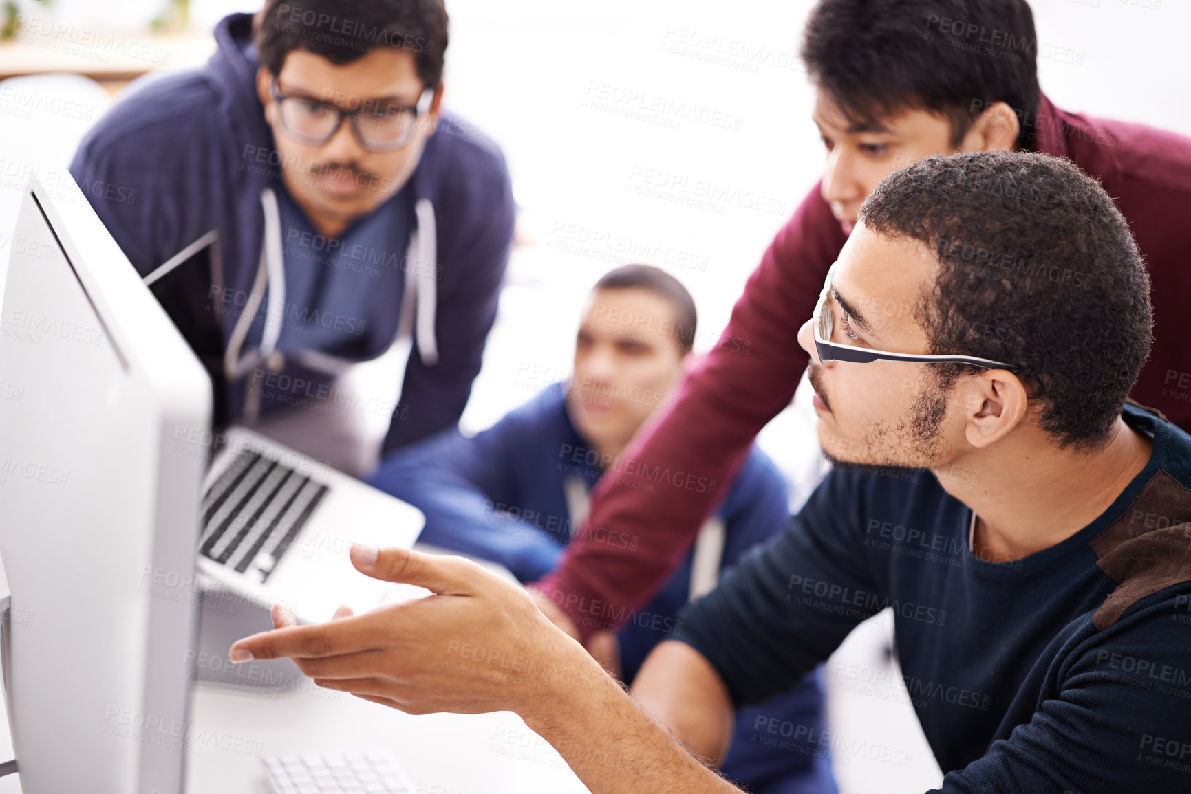 Buy stock photo Shot of a group of colleagues working together with a computer in an office