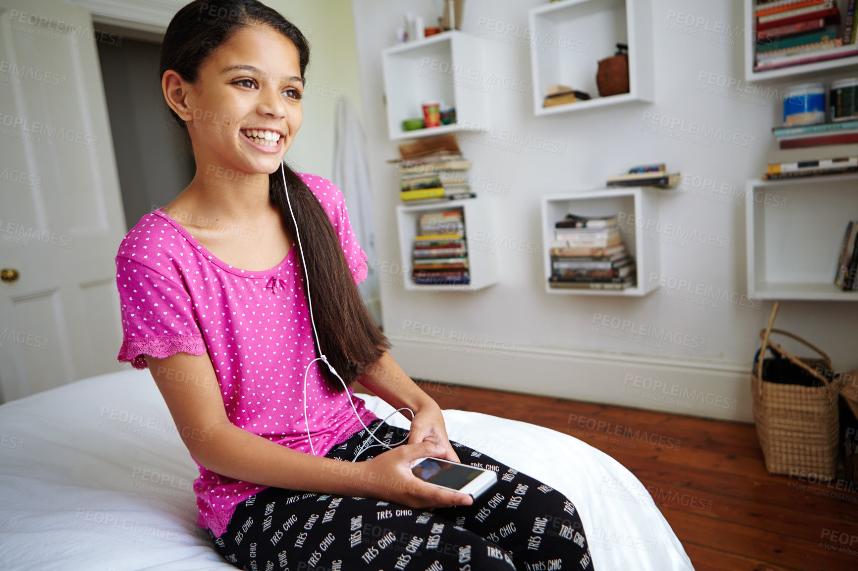 Buy stock photo Shot of a teenage girl listening to music in her bedroom