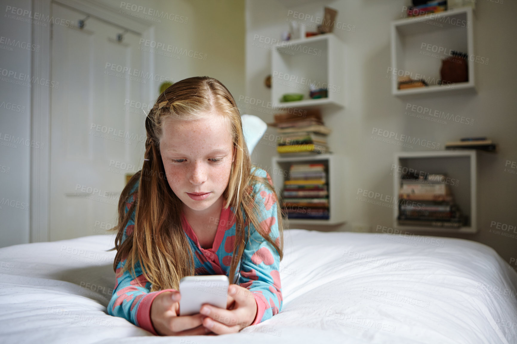 Buy stock photo Shot of a teenage girl texting in her bedroom