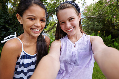 Buy stock photo Shot of two young girl friends taking a selfie together outside