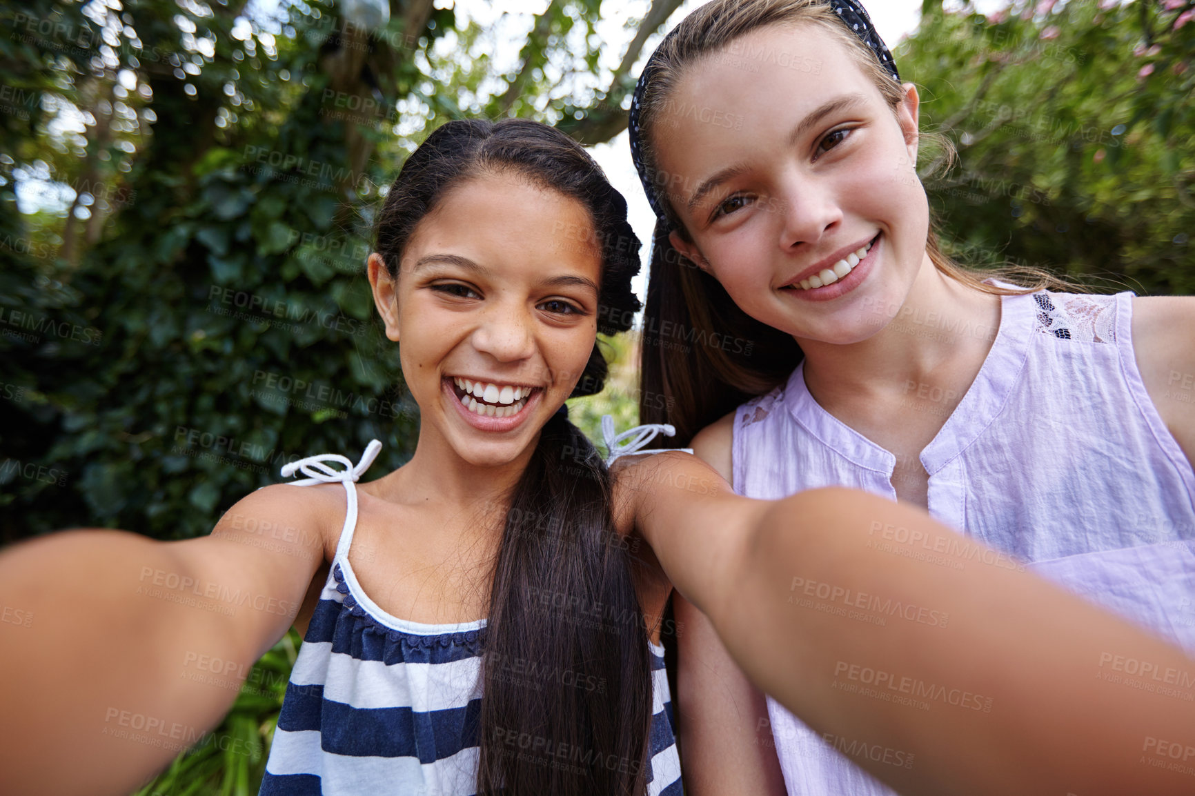 Buy stock photo Shot of two young girl friends taking a selfie together outside