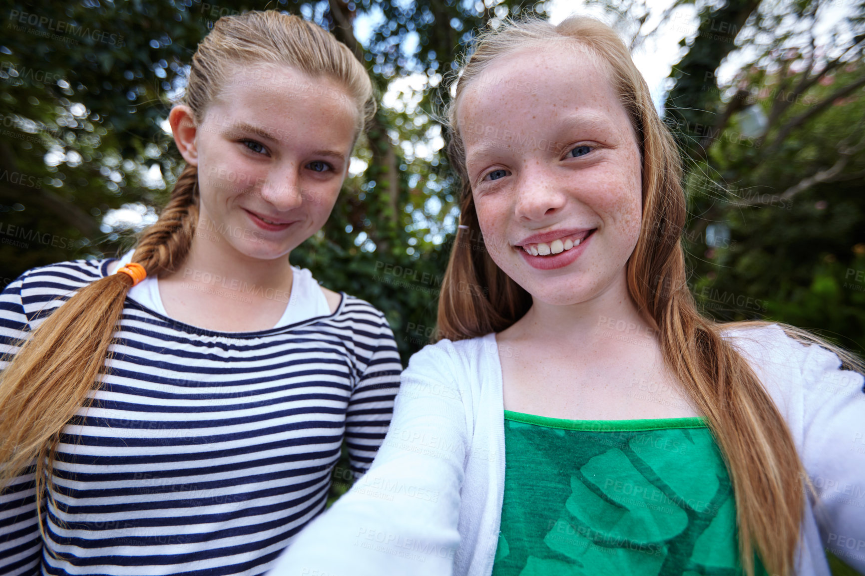 Buy stock photo Shot of two young girl friends taking a selfie together outside