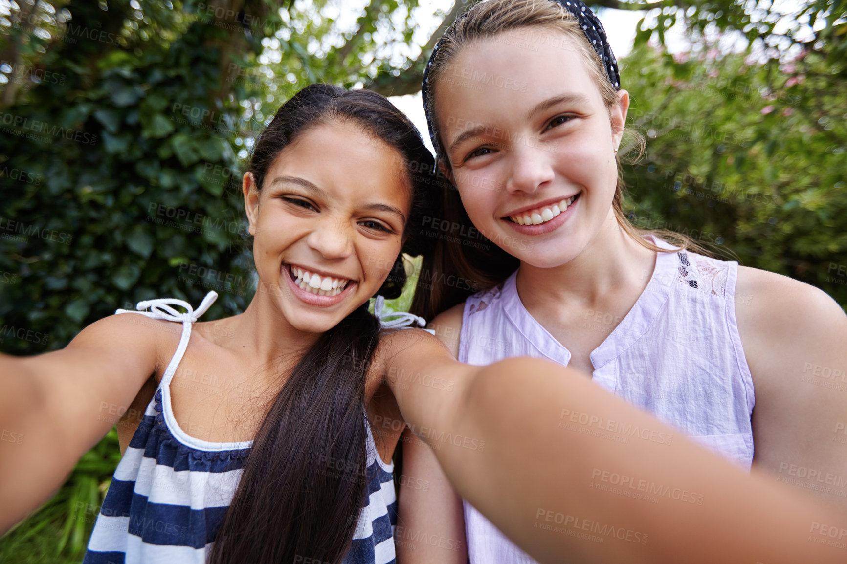 Buy stock photo Shot of two young girl friends taking a selfie together outside