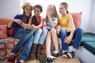 Buy stock photo Shot of a group of teenage friends using a cellphone  together