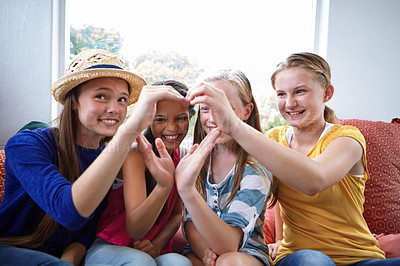 Buy stock photo Shot of a group of teenage friends using their hands to make the shape of a heart