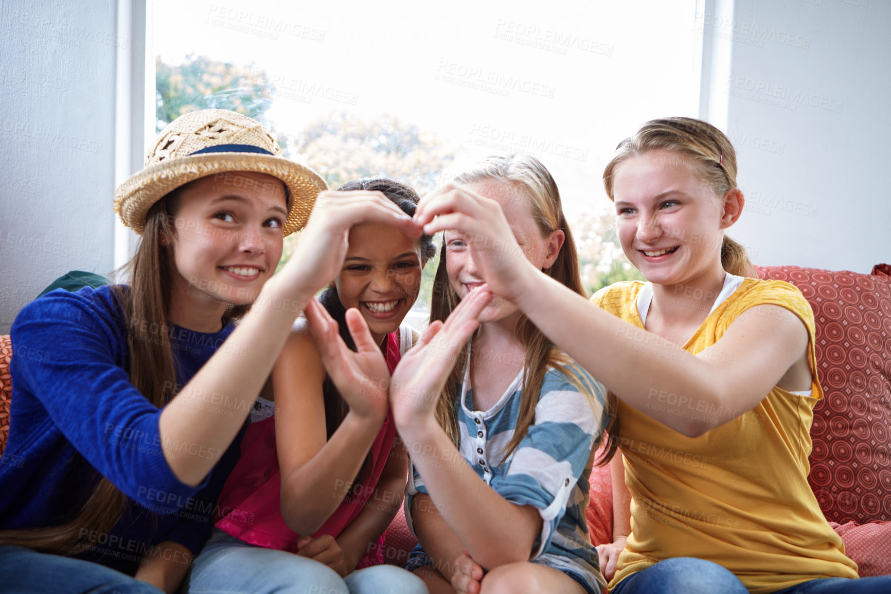 Buy stock photo Shot of a group of teenage friends using their hands to make the shape of a heart