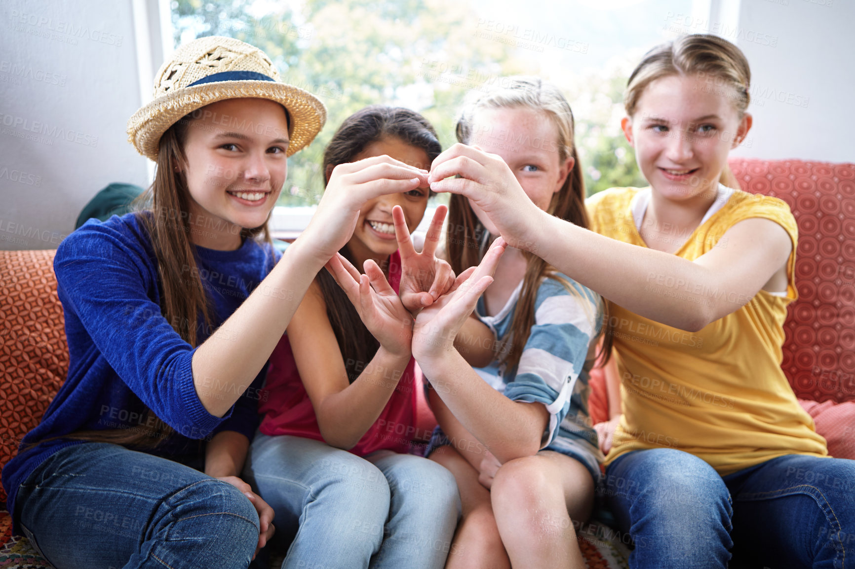 Buy stock photo Shot of a group of teenage friends using their hands to make the shape of a heart