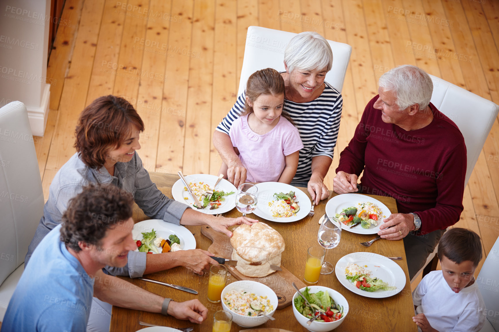 Buy stock photo High angle shot of a multi generational family sharing a meal together