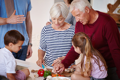 Buy stock photo Shot of a grandparents preparing a meal with their grandchildren