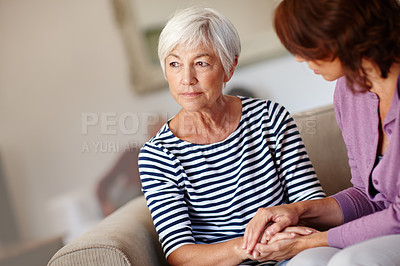 Buy stock photo Shot of a woman sitting beside her elderly mother at home