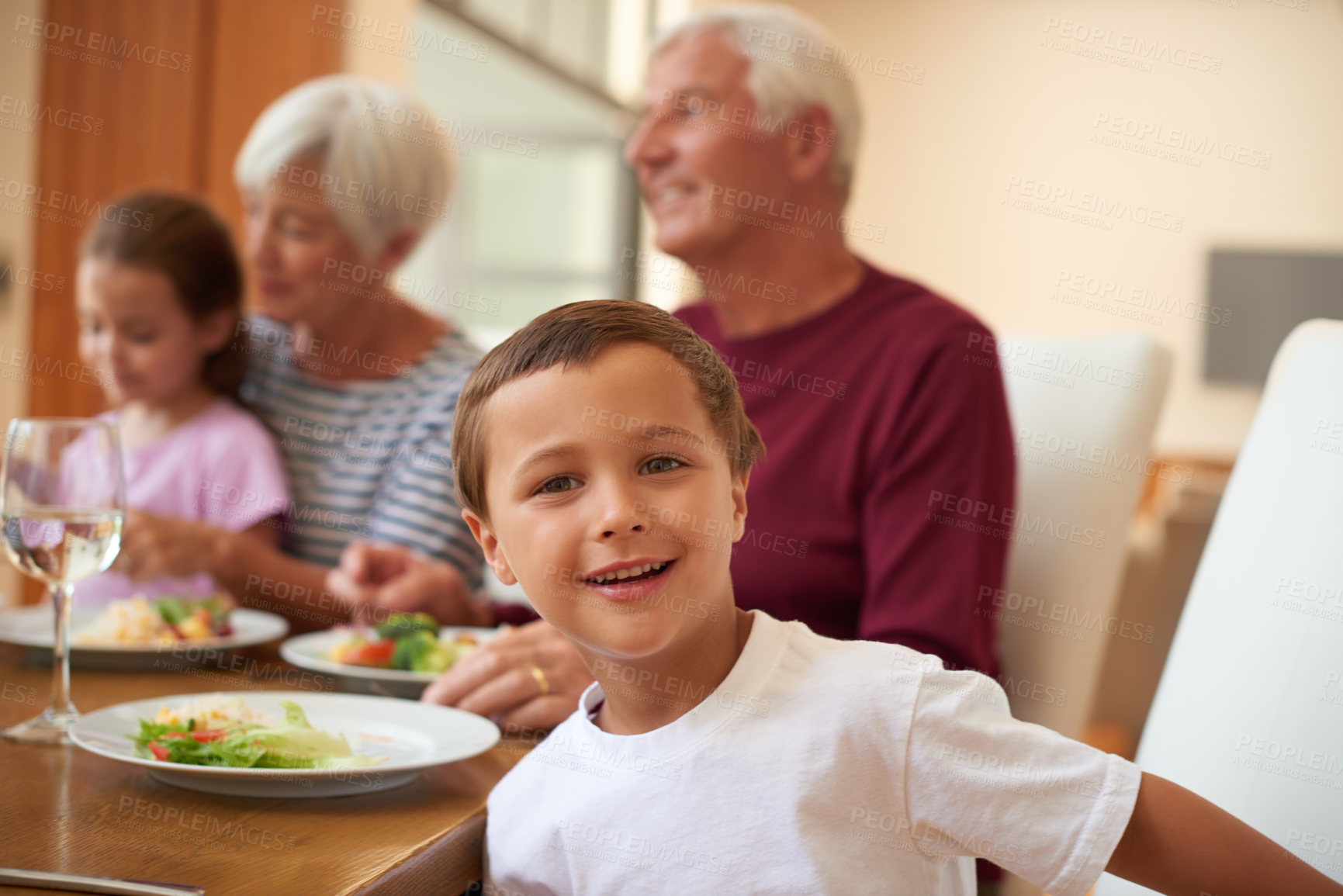 Buy stock photo Portrait of a little boy having a meal with his grandparents