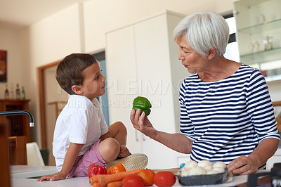 Buy stock photo Cropped shot of a grandmother preparing dinner with her grandchild in a kitchen