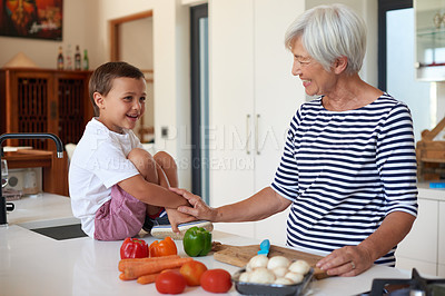 Buy stock photo Cropped shot of a grandmother preparing dinner with her grandchild in a kitchen