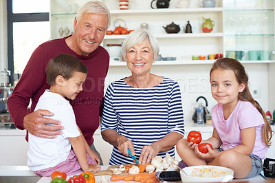Buy stock photo Portrait of grandparents preparing dinner with their grandchildren in a kitchen