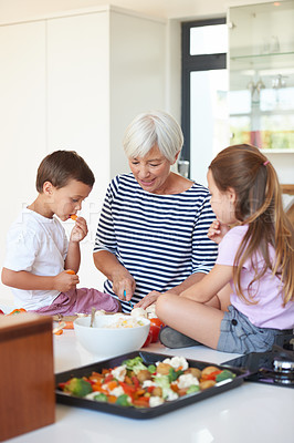 Buy stock photo Cropped shot of a grandmother washing vegetables with her grandchildren in a kitchen